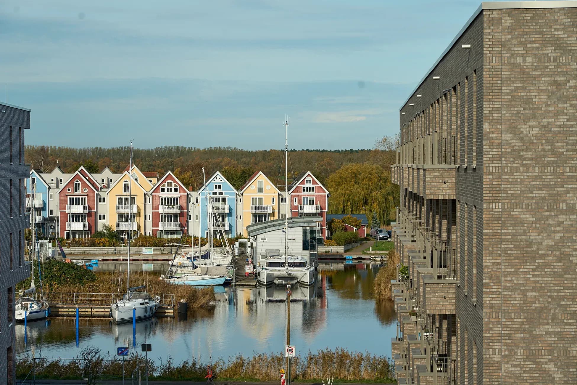 Speicher 7 am Ryck in Greifswald: Blick über den Hafen auf die bunten Giebelhäuser, rechts die Backsteinfassade mit Balkonen